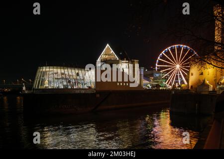 Nachtlandschaft am Rhein und Hintergrund des Hafens Weihnachtsmarkt in der Nähe des Schokoladenmuseums während des Weihnachtsmarkts im Winter. Stockfoto