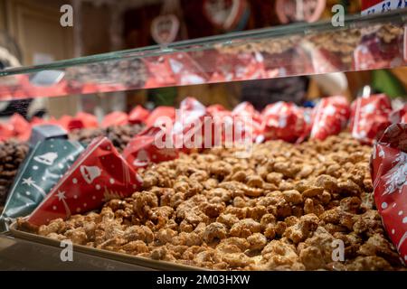 Selektive Fokussierung auf den Haufen gerösteter Mandeln auf dem Stand des Weihnachtsmarkts. Stockfoto