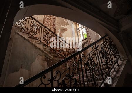 Ein Bild von Treppen in schlechtem Zustand, verlassene, verfallene Treppen in einer verlassenen Villa. Stockfoto