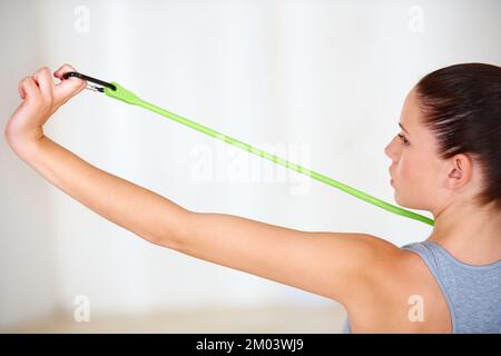 Widerstandstraining. Eine attraktive junge Frau, die im Fitnessstudio trainiert. Stockfoto