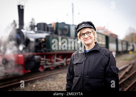 Bruchhausen Vilsen, Deutschland. 26.. November 2022. Dampflokomotivfahrer Insa Drechsler-Konukiewitz steht an einer Lokomotive der Museumseisenbahn im Diepholz-Viertel. Die Frau aus Bremen ist eine von nur wenigen Dampflokomotivinnen. Sie schult auch Nachwuchskräfte auf der Museumsschiene in Bruchhausen-Vilsen. Kredit: Moritz Frankenberg/dpa/Alamy Live News Stockfoto