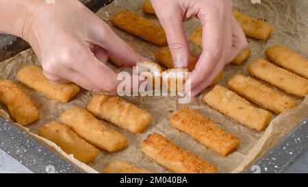 Backpfanne mit Fischstäbchen nah auf dem Küchentisch. Knusprig köstlich leicht paniert mit Brotkrümeln Fischstäbchen aus der Nähe Stockfoto