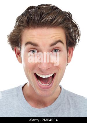 Ich habe tolle Neuigkeiten. Glücklicher junger Mann, der mit erhobenen Augenbrauen in die Kamera lächelt. Stockfoto