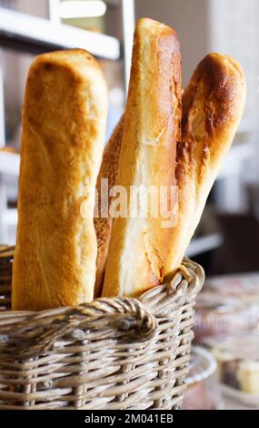 Ein Korb mit köstlichem Brot. Laibe mit köstlichem Brot in einem Korb in einer Bäckerei. Stockfoto