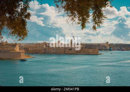 Blick vom Mausoleum in den Barakka-Gärten in Valletta, Malta an einem wunderschönen Sommertag. Malerische antike Häuser und Festung auf der anderen Seite der Bucht. Stockfoto