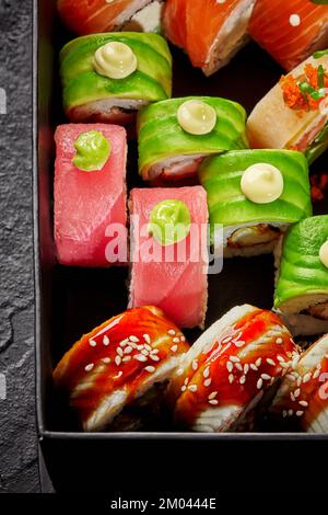 Set aus verschiedenen Uroaki-Sorten mit Lachs, Thunfisch, Aal und Avocado in einer Pappschachtel Stockfoto