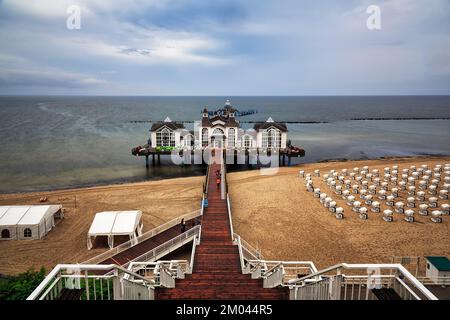 Holzbrückenleiter hinunter zum Pier Sellin, Einzeltouristen, Regenwetter an der Ostsee, leere Liegen, Blick von oben, lang Stockfoto