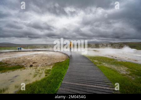 Tourist auf einem hölzernen Pfad, dampfende heiße Quellen, geothermisches Gebiet Hveravellir, isländische Highlands, Suðurland, Island, Europa Stockfoto