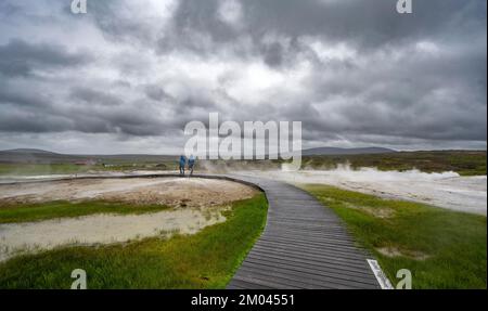 Touristen auf einem hölzernen Pfad, dampfende heiße Quellen, geothermisches Gebiet Hveravellir, isländische Highlands, Suðurland, Island, Europa Stockfoto