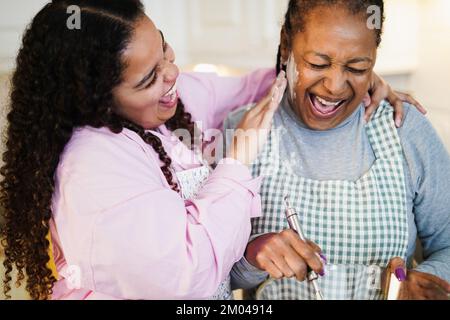 Afrikanische Mutter und Tochter haben Spaß beim Zubereiten von Obstkuchen zu Hause - Fokus auf Seniorengesicht Stockfoto