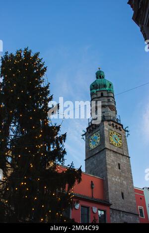 Weihnachtsmarkt in Innsbruck, Tirol, Österreich. Weihnachtsbaum mit Dekoration und mittelalterliches Rathaus in der europäischen Altstadt. Weihnachtsmesse am Abend. Stockfoto