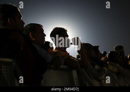 Doha, Katar. 03.. Dezember 2022. Arbeiter, hauptsächlich aus Indien, Bangladesch, Nepal und anderen ärmeren asiatischen Ländern, sehen das Spiel Argentinien-Australien auf einer großen Leinwand im Asian Town Cricket Stadium. Im Cricket-Stadion, das offiziell als „Fan Zone Industrial Area“ bezeichnet wird, sehen sich jeden Abend Tausende von ausländischen Arbeitern die Fußballspiele der Weltmeisterschaft an. Kredit: Christian Charisius/dpa/Alamy Live News Stockfoto