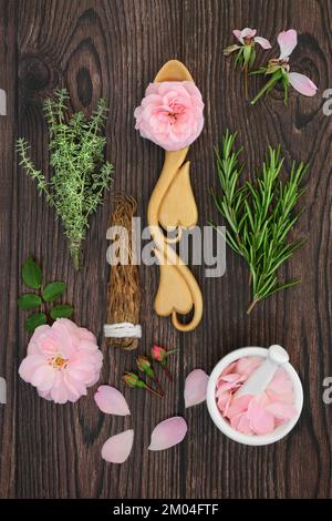 Zutaten für magischen Zauberspruch Liebestrank natürliche Rezeptur mit Rosenblumen, Rosmarin, Thymian und Ginseng Kräutern. Stockfoto