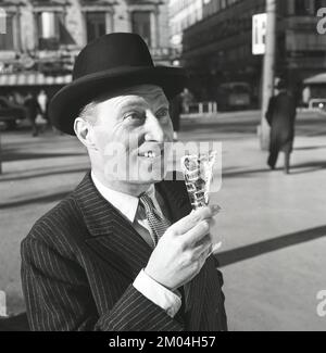 Eis in den 1960er Jahren. Ein gut gekleideter Herr in Anzug und Hut genießt an einem sonnigen Tag ein Eis. Schweden 1965 Kristoffersson Ref CN4-6 Stockfoto