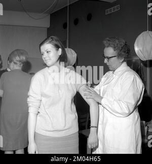 Impfstoff in den 1960er Jahren. Eine Krankenschwester injiziert einer jungen Frau einen Impfstoff in den Arm. Schweden 1965 Conard Ref 5011 Stockfoto