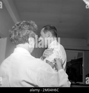 Impfstoff in den 1960er Jahren. Eine Krankenschwester injiziert einem Mann einen Impfstoff in den Arm. Schweden 1965 Conard Ref 5011 Stockfoto