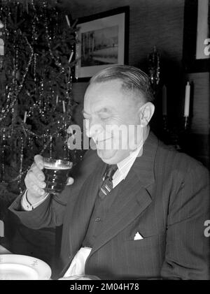 zu weihnachten in den 1940er. Ein Mann isst zu weihnachten zu Abend und sieht auch so aus, als würde er das typische traditionelle weihnachtsgetränk genießen. Schweden dezember 1940 Kristoffersson 42-8 Stockfoto