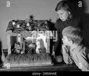 Weihnachten in den 1950er. Zwei Kinder mit einer Krippenszene, Jesuskind in einer Krippe, Maria und Joseph. Schweden 1950 Ref. I2144 Stockfoto