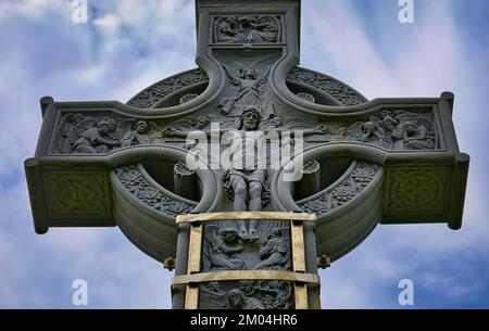 Lord Carbery's Cross zeigt biblische Szenen und unterstützt von Edelstahlverstärkung, Croachna Hill, West Cork, Irland Stockfoto