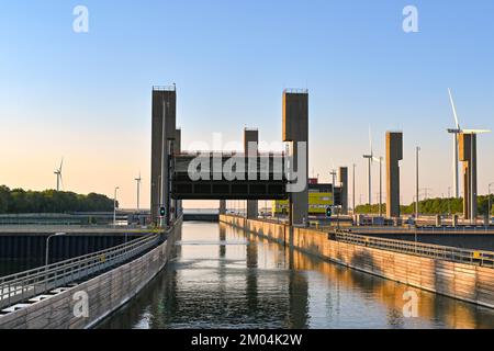 Rilland, Niederlande - August 2022: Eintritt zu einer großen Kanalschleuse in der Dämmerung mit angehobenem Schleusentor, damit Schiffe einfahren können Stockfoto