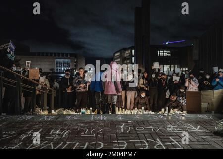 Washington, Universitätsbezirk, USA. 28.. November 2022. Vor dem Veranstaltungsort stehen zwei Kinder, die den „White Paper“-Protest an der University of Washington unterstützen. An der Universität von Washington versammelten sich mehr als zweihundert Menschen, um Solidarität mit dem "Weißbuch"-Protest in China zu zeigen. Die Demonstranten forderten die chinesische Regierung auf, alle Demonstranten freizulassen, China zu befreien, und forderten Präsident Xi auf, zurückzutreten. Die Demonstranten zündeten jedoch eine Kerze an, um eine Tragödie unter exzessiver Kontrolle zu symbolisieren, um ihre Unterstützung für die Tragödie des Urumqi-Feuers zu zeigen. Diese Tragödie hat den gekostet Stockfoto