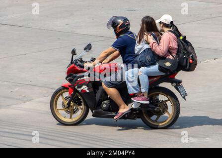 SAMUT PRAKAN, THAILAND, 02 2022. MÄRZ, Trio - ein Mann mit zwei Frauen, fährt ein Motorrad Stockfoto
