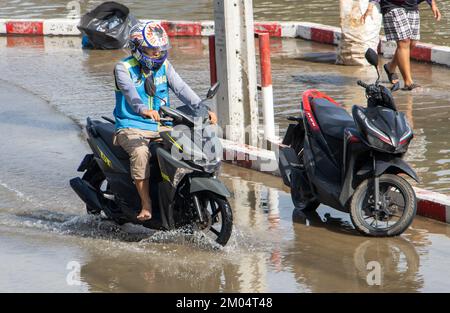 SAMUT PRAKAN, THAILAND, Okt 29 2022, Ein Moto Taxi fährt durch eine überflutete Straße Stockfoto