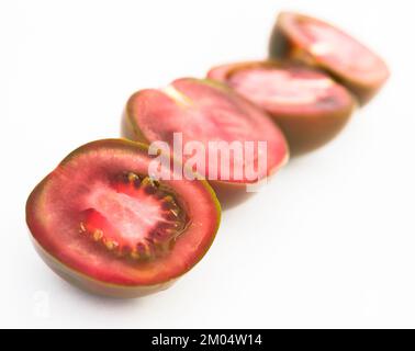 Schwarze Hälften von Tomaten auf weißem Hintergrund Stockfoto