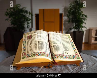 Embrach, Schweiz - 23. Oktober 2022: Ein offenes Bibelbuch auf einem Tisch in der evangelisch-reformierten Kirche in Embrach. Stockfoto