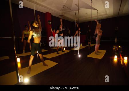 Lemberg, Ukraine, 29. November 2022. Ukrainische Frauen besuchten während eines Stromausfalls einen Tanzkurs in einem Fitnessclub. Der Klassenraum wird von Kerzen und Mobiltelefonen beleuchtet. Russland marschierte am 24. Februar 2022 in die Ukraine ein und löste damit den größten militärischen Angriff in Europa seit dem Zweiten Weltkrieg aus Stockfoto