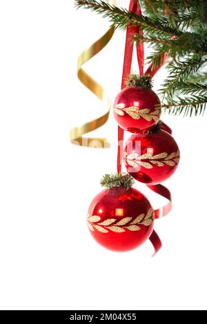 Weihnachtsdekorationen. Drei rote Kugeln mit goldenem Muster auf dem Weihnachtsbaum Stockfoto