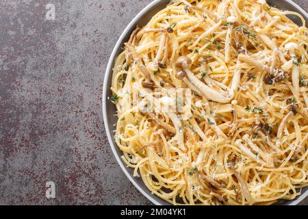 Spaghetti mit Pilzen, cremiger Sauce und Thymian auf dem Teller auf dem Tisch. Horizontale Draufsicht von oben Stockfoto