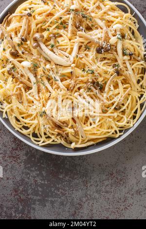 Spaghetti-Pasta mit cremiger Pilzsauce, Käse und Thymian auf dem Teller auf dem Tisch. Vertikale Draufsicht von oben Stockfoto