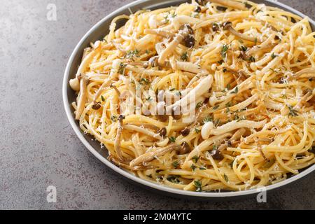 Spaghetti mit Pilzen, cremiger Sauce und Thymian auf dem Teller auf dem Tisch. Horizontal Stockfoto