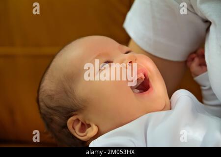 Das Neugeborene lächelt und lacht. Zeigt Emotionen Stockfoto