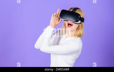 Mädchen benutzen moderne Technologie über Headset spielen Shooter-Spiel. Lady mit Waffengesten. Interaktive virtuelle Realität. Kopfmontiertes Display für Frauen Stockfoto