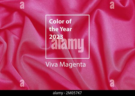 Farbe des Hintergrunds des Jahres 2023. Neue Trendfarbe Magenta auf rot-violettem Stoffhintergrund. Hochwertiges Foto Stockfoto