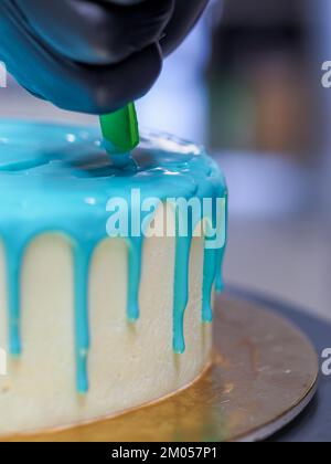 Beutelfüllung auf Milcheis Tropfkuchen in türkisfarbenem Tüpfeltuch zur Geburtstagsfeier Stockfoto