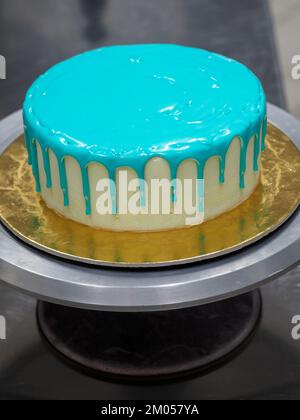 Beutelfüllung auf Milcheis Tropfkuchen in türkisfarbenem Tüpfeltuch zur Geburtstagsfeier Stockfoto