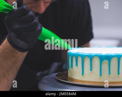 Beutelfüllung auf Milcheis Tropfkuchen in türkisfarbenem Tüpfeltuch zur Geburtstagsfeier Stockfoto