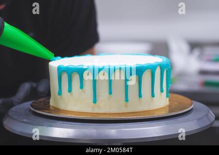 Beutelfüllung auf Milcheis Tropfkuchen in türkisfarbenem Tüpfeltuch zur Geburtstagsfeier Stockfoto