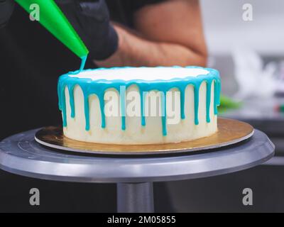 Beutelfüllung auf Milcheis Tropfkuchen in türkisfarbenem Tüpfeltuch zur Geburtstagsfeier Stockfoto