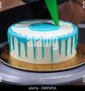 Beutelfüllung auf Milcheis Tropfkuchen in türkisfarbenem Tüpfeltuch zur Geburtstagsfeier Stockfoto