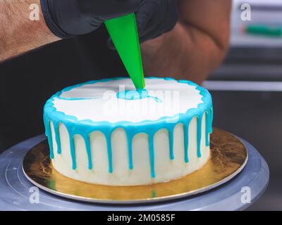 Beutelfüllung auf Milcheis Tropfkuchen in türkisfarbenem Tüpfeltuch zur Geburtstagsfeier Stockfoto