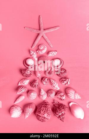 Ein Set mit Muscheln und einem Seestern, der als Weihnachtsbaum angelegt wurde. Alternativer Weihnachtsbaum. Kreativer Hintergrund zu Weihnachten. Vertikale Ausrichtung. T Stockfoto