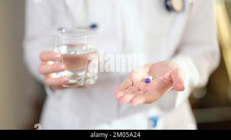 Frau Doktor bietet Pille gegen Krankheit zu nehmen. Stockfoto