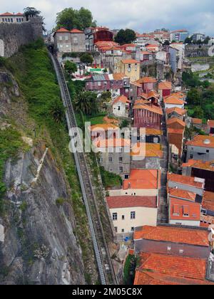 Blick auf die steile Seilbahn Guindais und historische malerische Häuser in der Nähe des Douro Riverbank, der Luis I Brücke, Porto Portugal Stockfoto