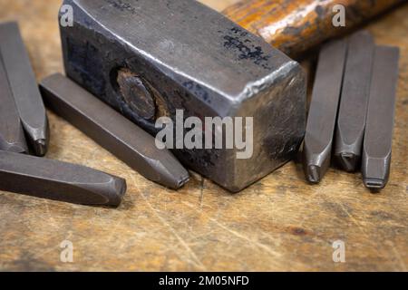 Hammer und Stanznummern auf einer Werkbank Stockfoto