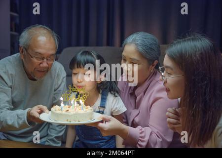 Glückliche asiatische Familie Großeltern und Mutter feiern Geburtstagsparty mit Kuchen Stockfoto