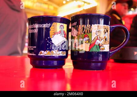 Hanau, Deutschland - 15. Dezember 2019: Tassen für Heißgetränke wie Gluhwein und Kinderpunsch auf dem Weihnachtsmarkt in Hanau. Stockfoto
